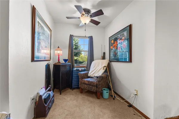 a view of a workspace with furniture and a window