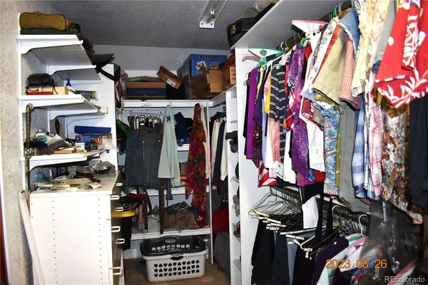 a view of walk in closet with clothes and shoes