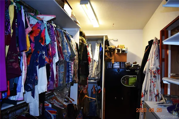 a view of walk in closet with clothes and shoes