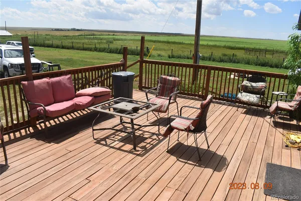 a view of a patio with wooden floor table and chairs