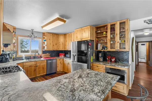 a kitchen filled with stainless steel appliances kitchen island granite countertop a refrigerator stove and oven