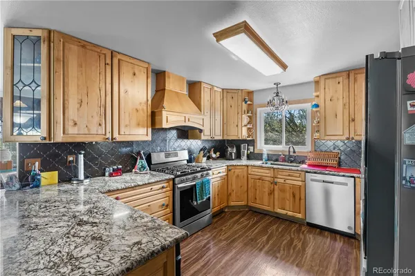 a kitchen with stainless steel appliances granite countertop a sink stove and refrigerator