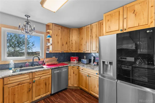 a kitchen with stainless steel appliances a sink cabinets and wooden floor