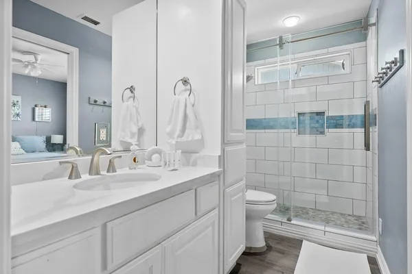 a bathroom with a double vanity sink toilet and shower