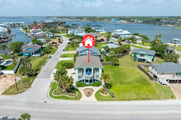 an aerial view of a house with swimming pool and lake view