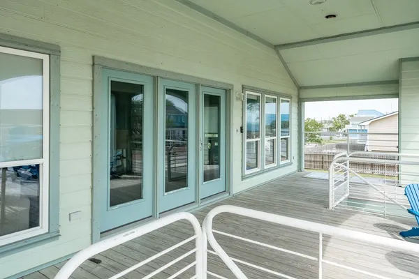 a view of a porch with a floor to ceiling window and wooden floor