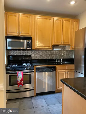 a kitchen with stainless steel appliances granite countertop a stove and a refrigerator
