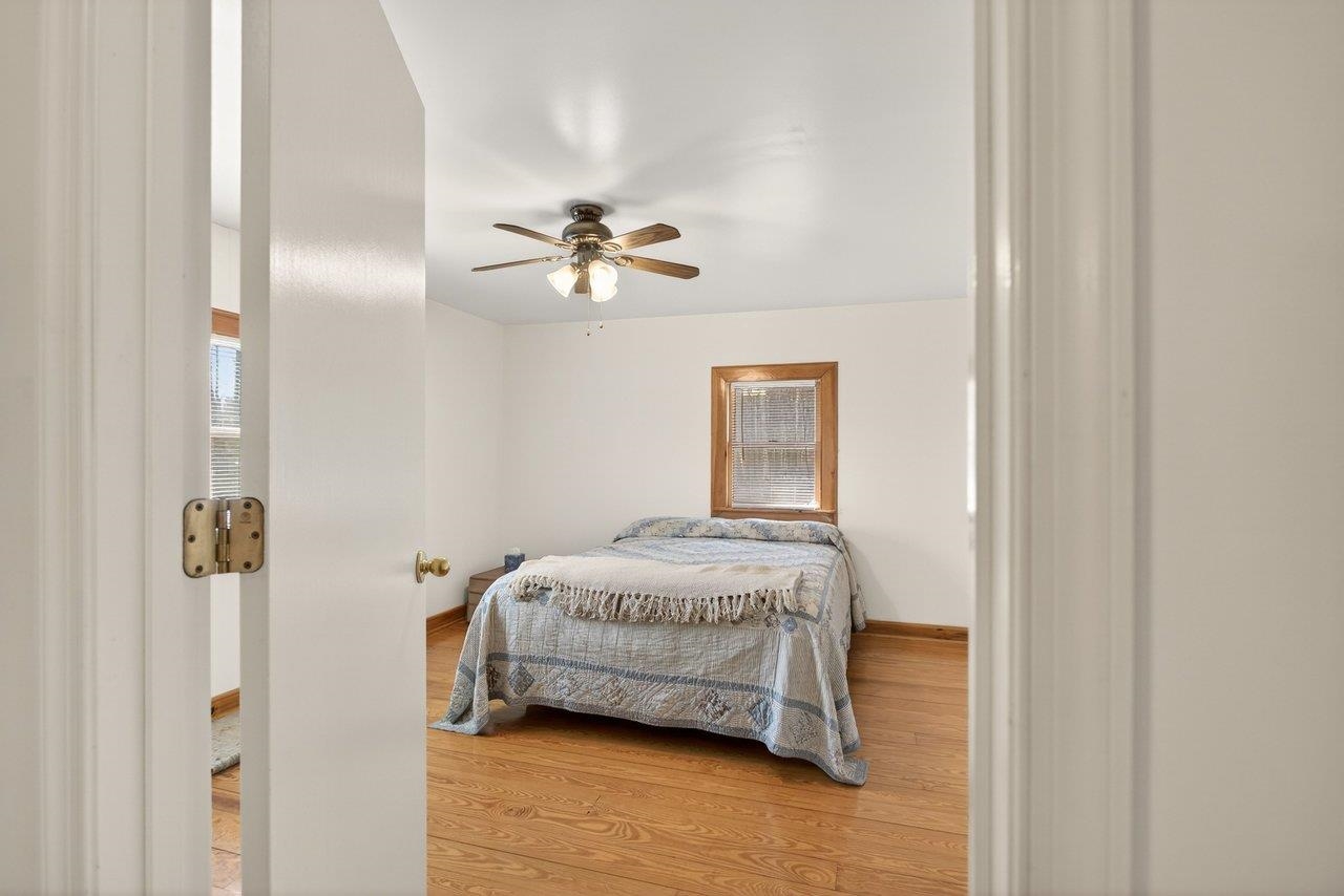 10677 Allman Road Dayton, VA 22821 - Photo 19 of 57 a bedroom with a bed and a chandelier