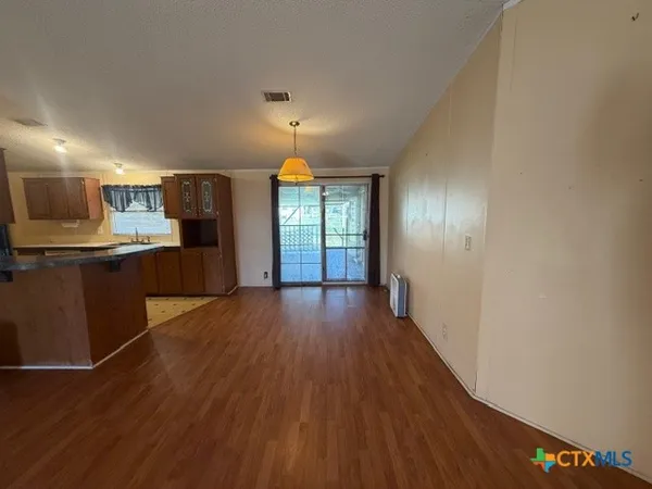 a view of a kitchen with wooden floor and electronic appliances