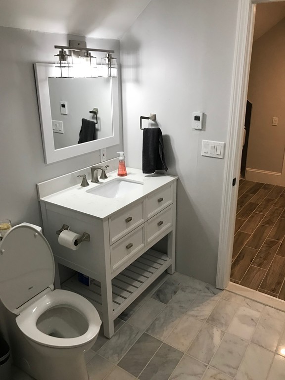 18 Park Street Boston, MA 02136 - Photo 13 of 20 a bathroom with a toilet a sink a mirror and vanity