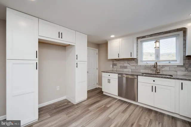 a kitchen with granite countertop white cabinets and white appliances