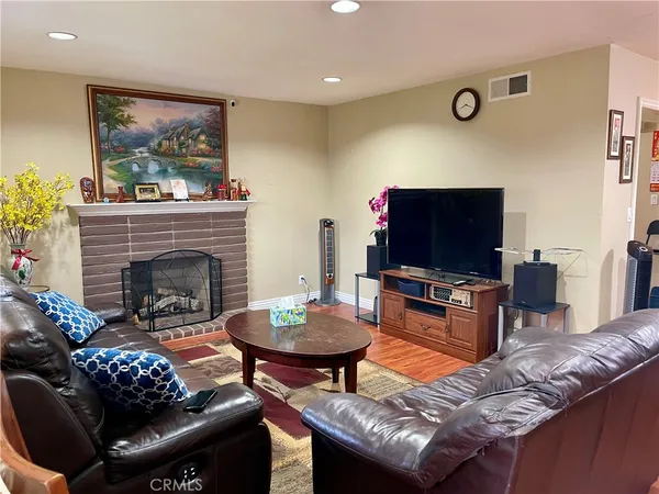 a living room with furniture a flat screen tv and a fireplace