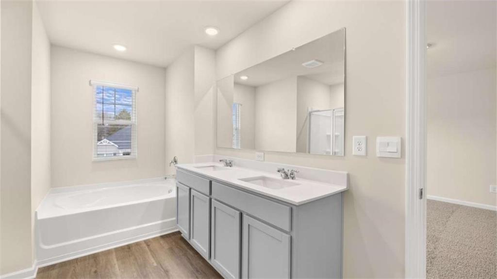 100 Planters Row Perry, GA 31069 - Photo 17 of 37 a bathroom with a sink a mirror and a bathtub