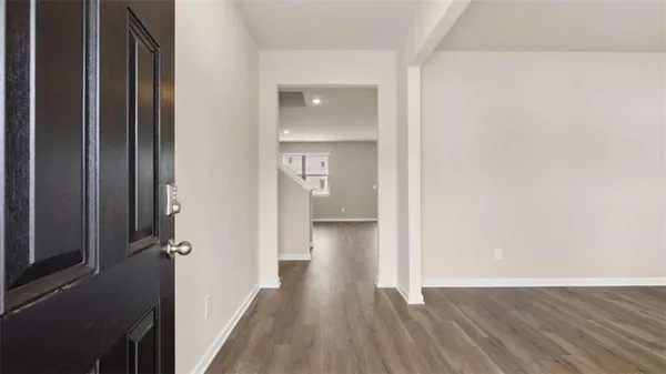 a view of a hallway with wooden floor and cabinet