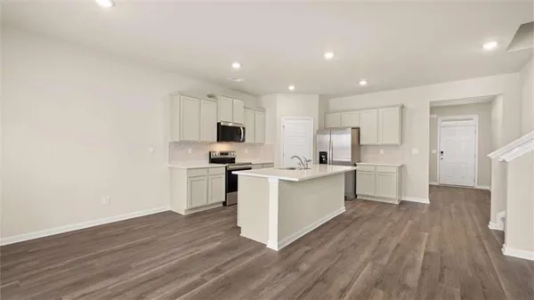 a kitchen with a sink a counter top space stainless steel appliances and cabinets
