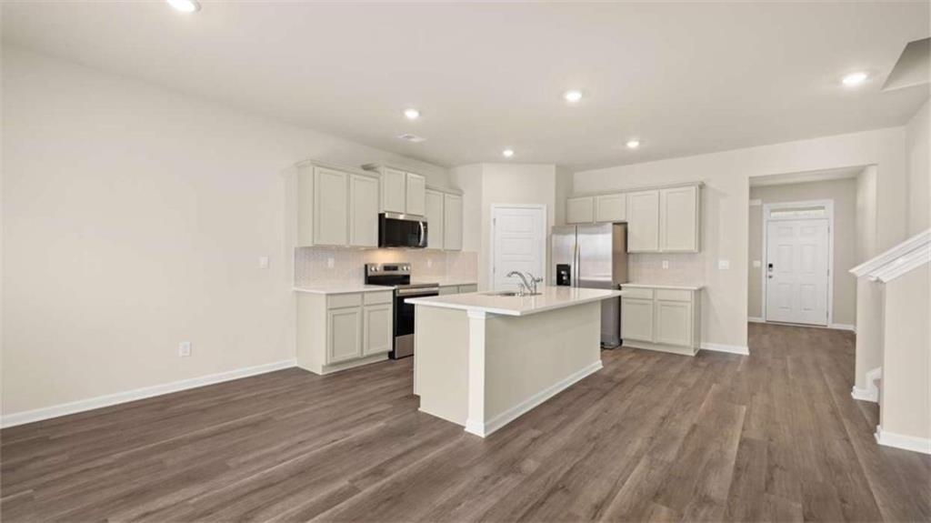 100 Planters Row Perry, GA 31069 - Photo 9 of 37 a kitchen with white cabinets and stainless steel appliances