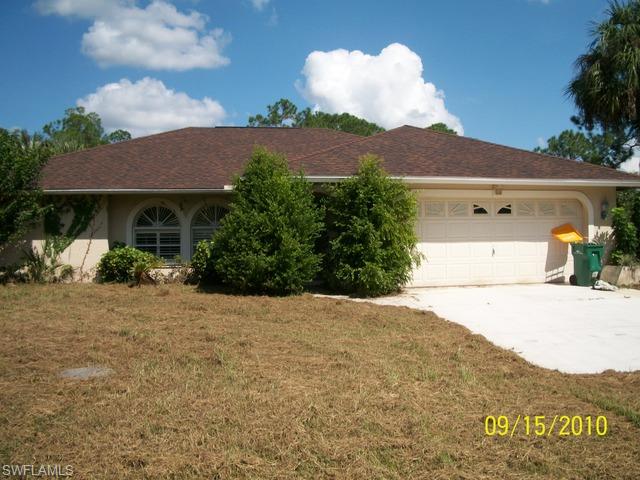 240 9th Street Southwest Naples, FL 34117 - Photo 1 of 8 a front view of a house with a yard and mountain