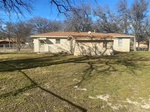 a view of a house with backyard and trees