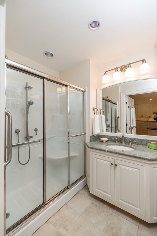 25 Haven Way Beverly, MA 01915 - Photo 29 of 42 a bathroom with a granite countertop sink two mirror and a glass door shower