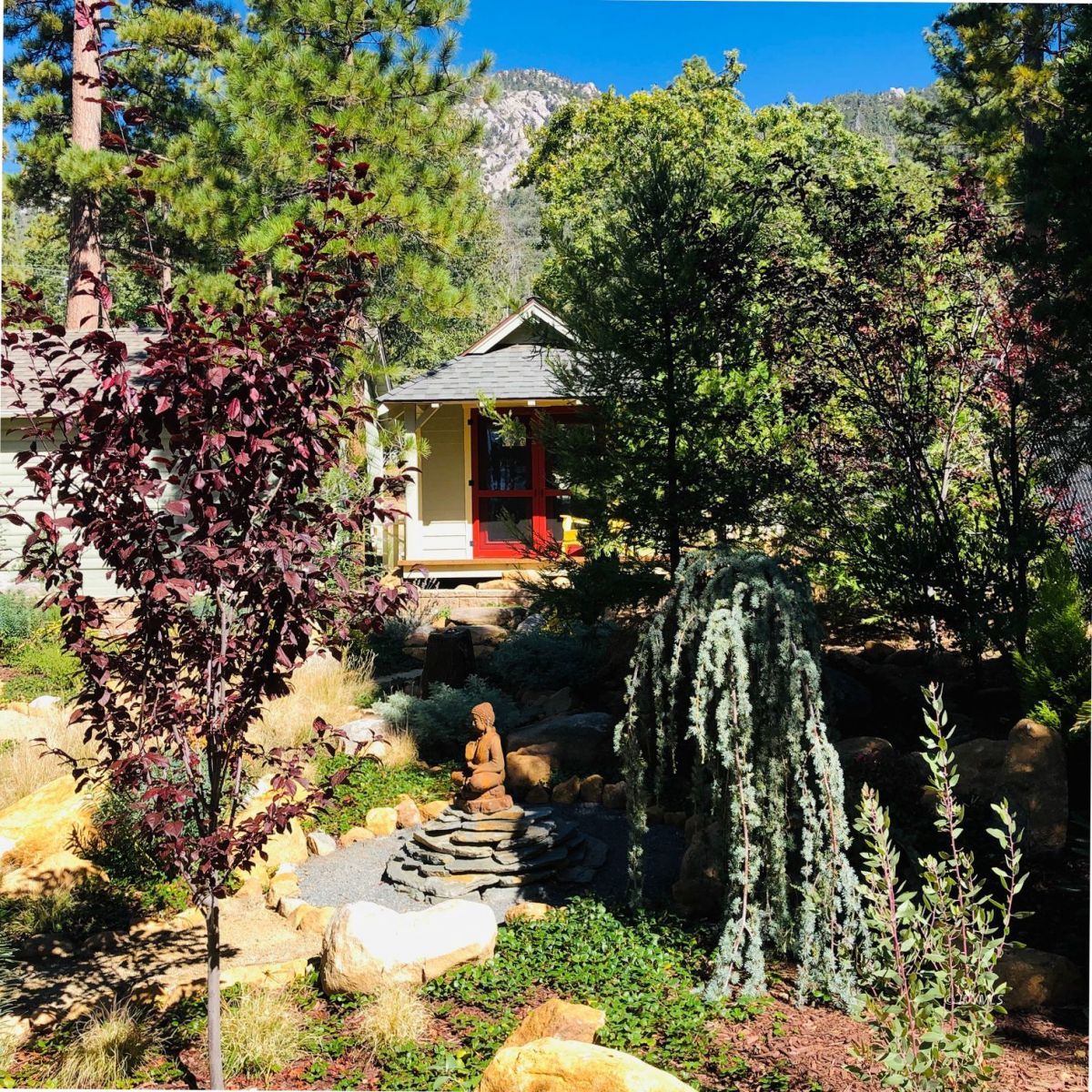 25505 Seneca Road Idyllwild, CA 92549 - Photo 51 of 60 a backyard of a house with table and chairs under an umbrella