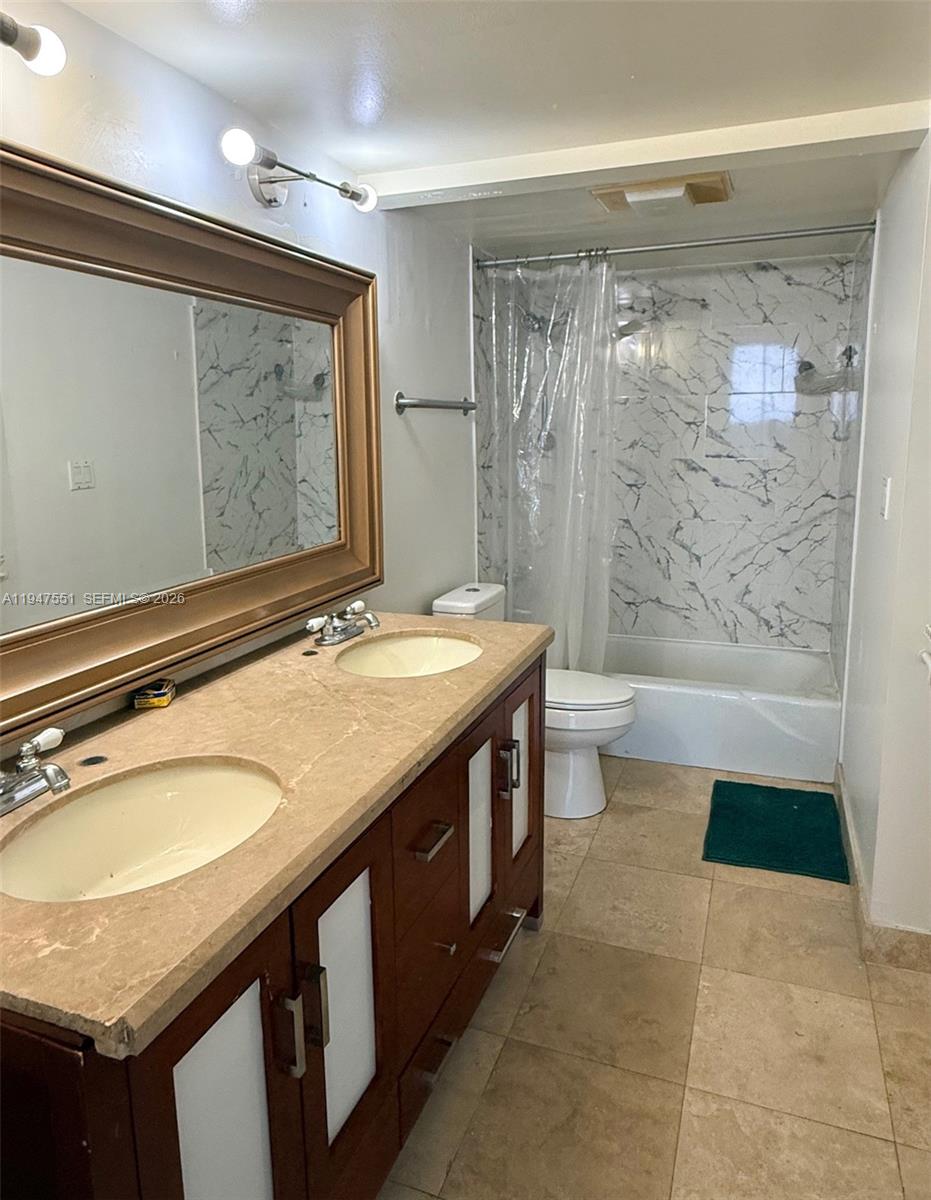 4200 Inverrary Boulevard, Unit 3604 Lauderhill, FL 33319 - Photo 7 of 14 a bathroom with a granite countertop sink a toilet a mirror and shower