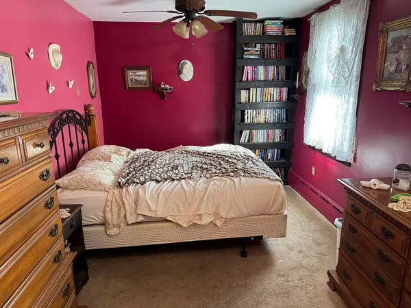 a bedroom with a bed and dresser with window