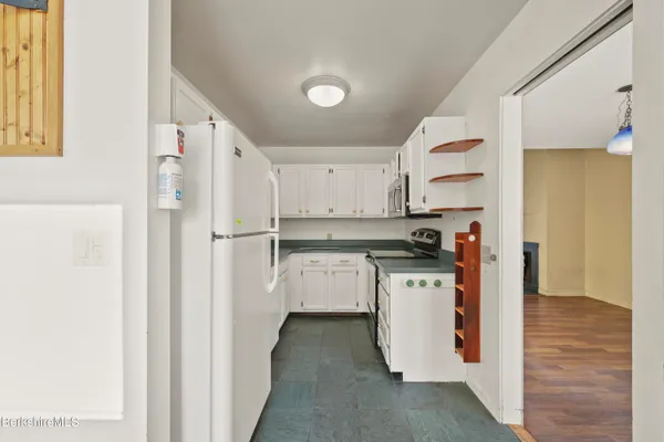 a kitchen with a refrigerator a sink and dishwasher with wooden floor