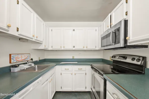 a kitchen with stainless steel appliances granite countertop a sink stove and cabinets