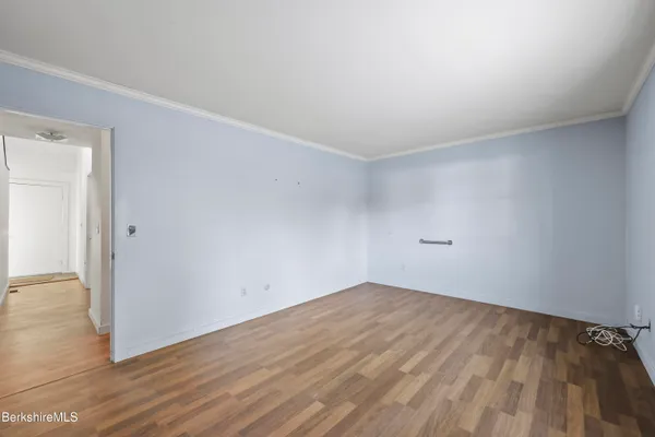 a view of an empty room with wooden floor