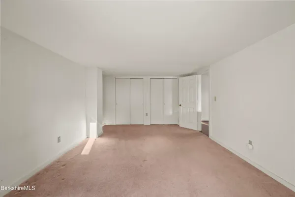 a bathroom with a granite countertop sink vanity mirror and toilet