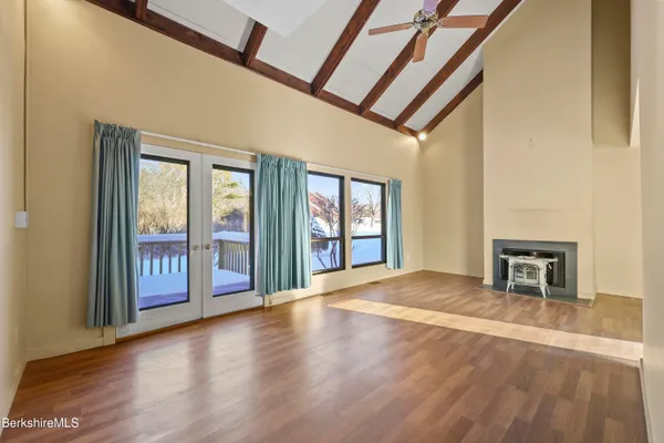 a view of an empty room with glass door and a window