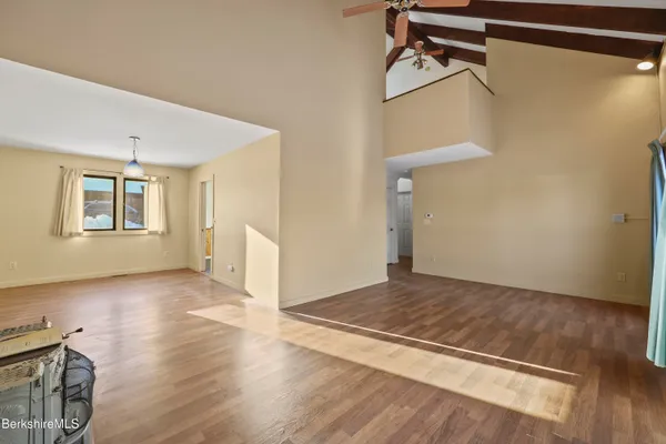 a view of a livingroom with wooden floor and stairs