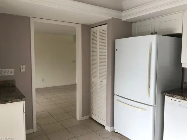 a white refrigerator freezer and a stove sitting inside of a kitchen