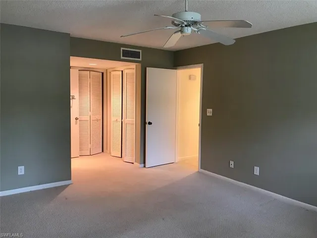 en empty room with windows and fan