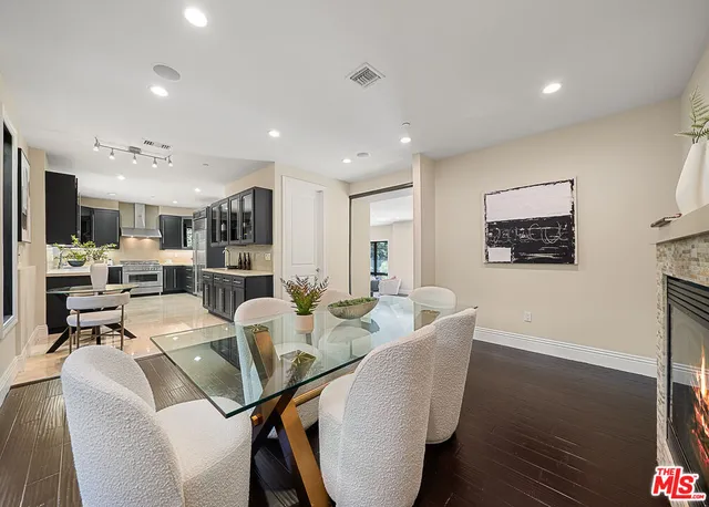 a view of a dining room with furniture a kitchen and chandelier