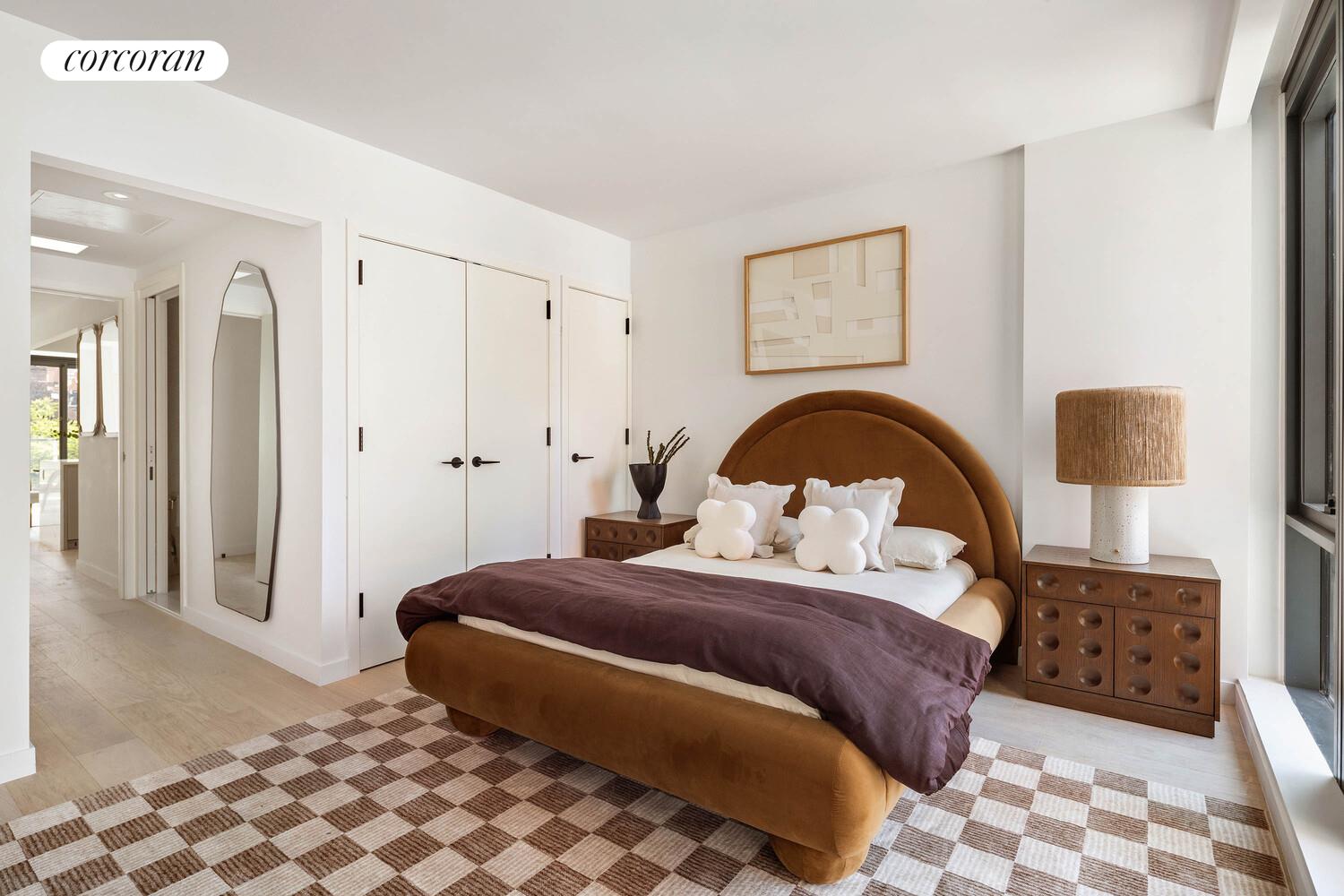 355 West 39th Street, Unit 6A Manhattan, NY 10018 - Photo 5 of 9 a bedroom with a bed and a lamp on dresser