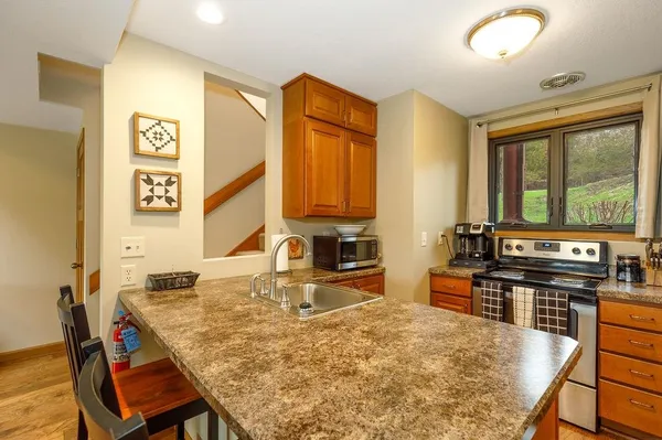 a kitchen with stainless steel appliances granite countertop a stove a sink and a refrigerator