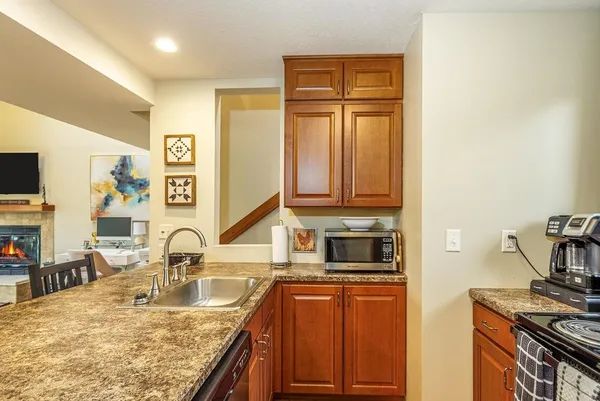 a kitchen with stainless steel appliances granite countertop a sink and dishwasher a stove top oven with wooden floor
