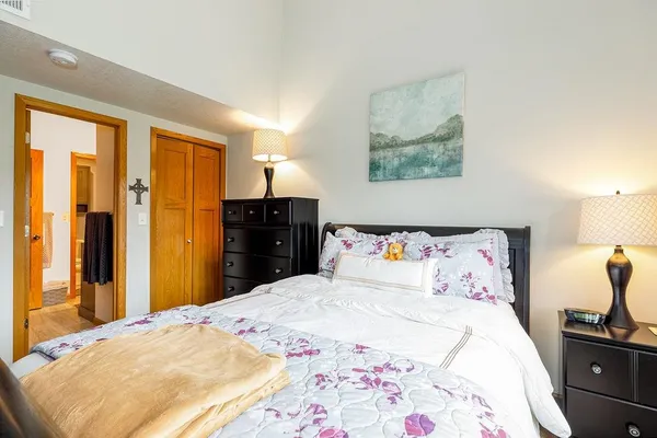 a bedroom with a large bed and a chandelier