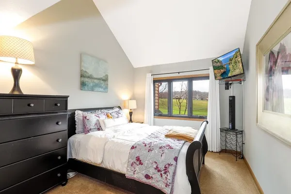 a bedroom with a bed and a dresser next to a window