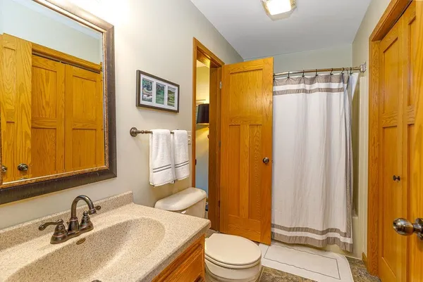a bathroom with a granite countertop sink toilet and shower