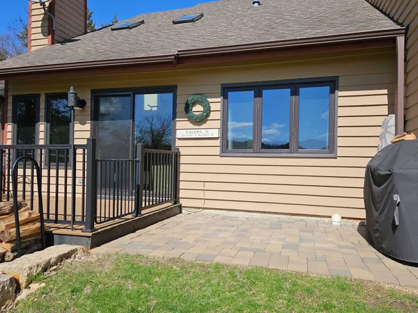 a view of a house with a door and wooden bench