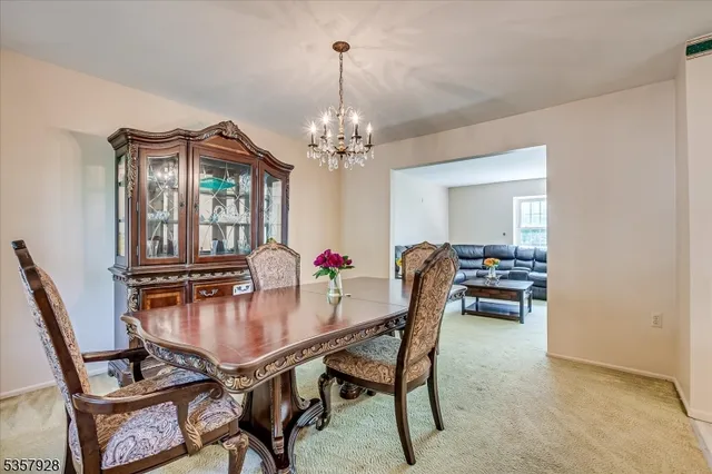 a dining room with furniture a chandelier and window