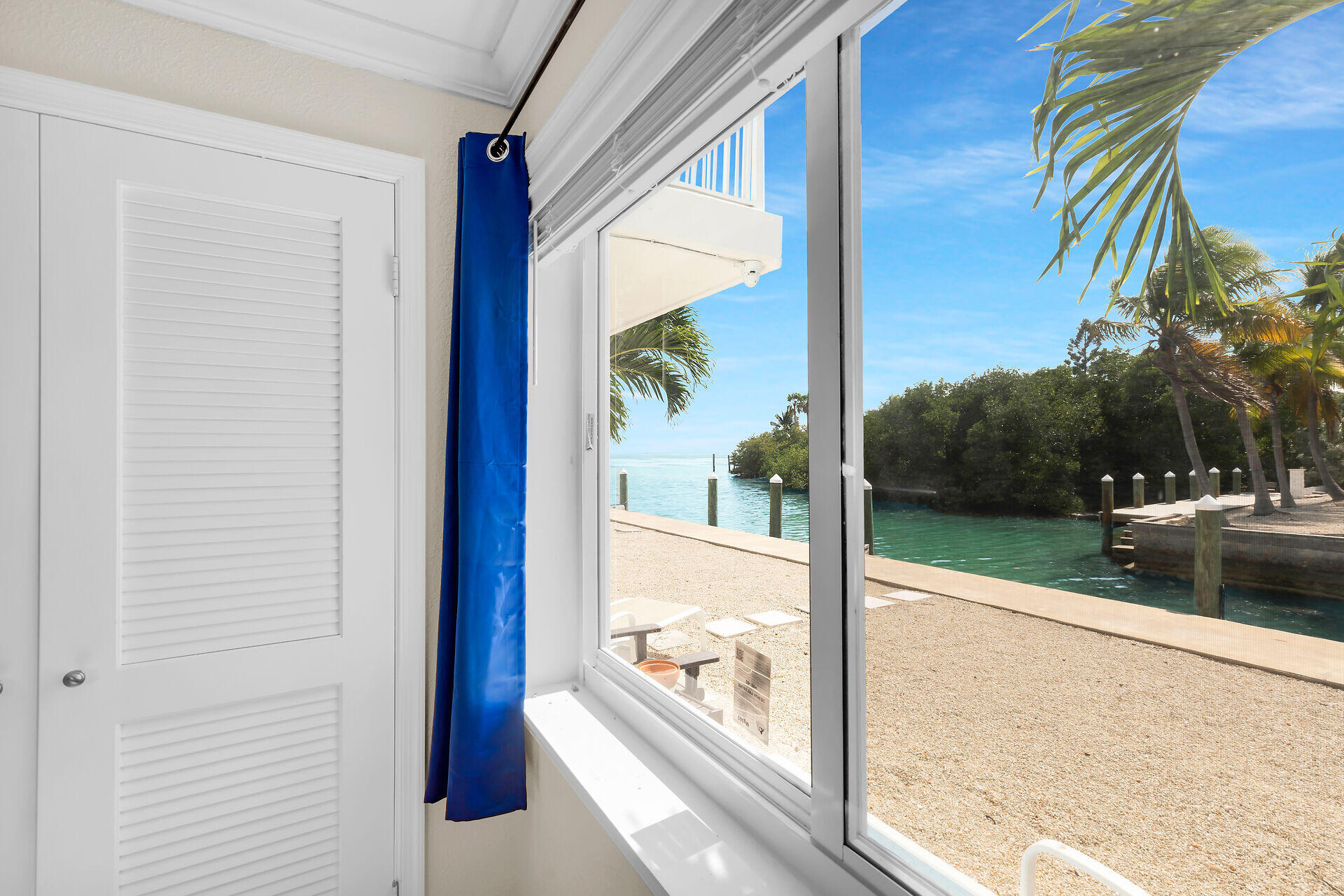 1215 97th Street, Unit 6 Marathon, FL 33050 - Photo 12 of 20 a view of a glass door with a tree