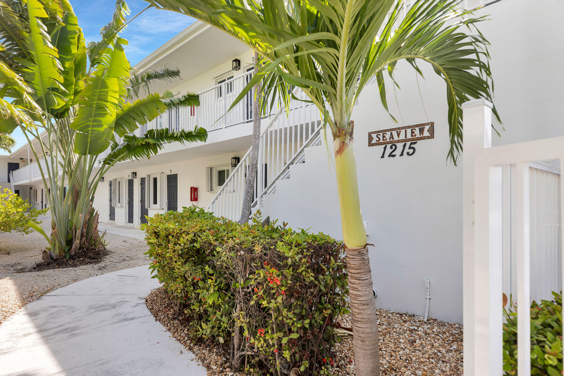 1215 97th Street, Unit 6 Marathon, FL 33050 - Photo 15 of 20 a view of a house with a yard and potted plants