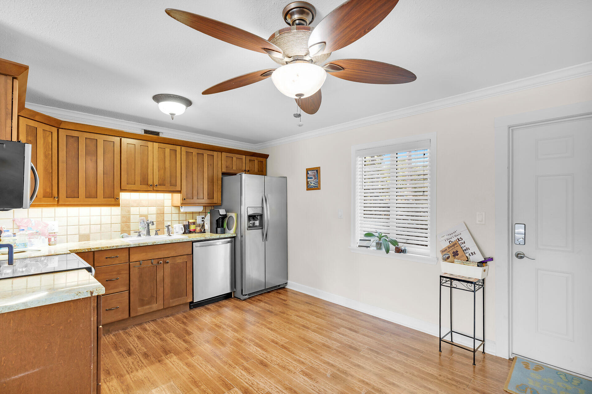 1215 97th Street, Unit 6 Marathon, FL 33050 - Photo 5 of 20 a kitchen with stainless steel appliances granite countertop a refrigerator a stove a sink dishwasher and a dining table with wooden floor