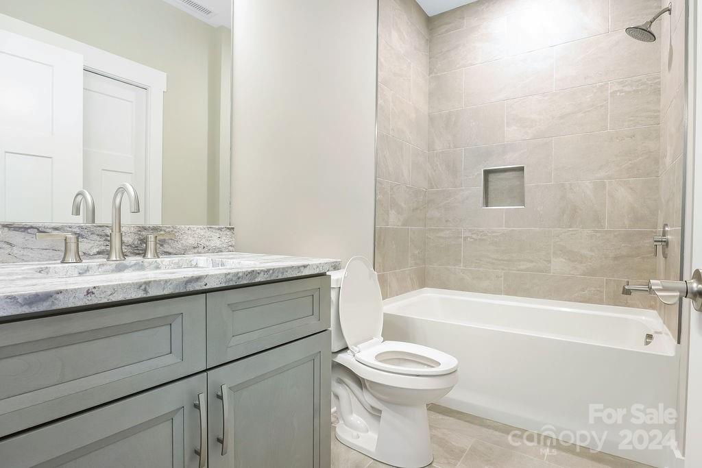 3 Craftsman Overlook Ridge Arden, NC 28704 - Photo 11 of 45 a bathroom with a granite countertop toilet a sink and bathtub