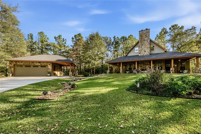 an aerial view of a house with a yard and large trees