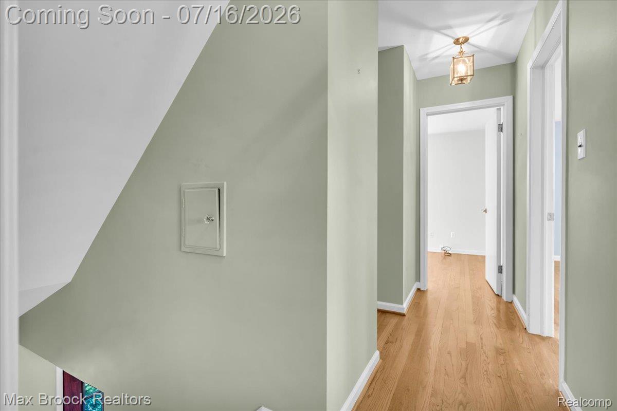 1292 Yorkshire Road Birmingham, MI 48009 - Photo 17 of 47 Hallway featuring wood-finish flooring, light green wall paint, white trim, and a ceiling-mounted light fixture