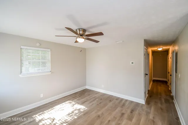 a view of a big room with wooden floor and a window